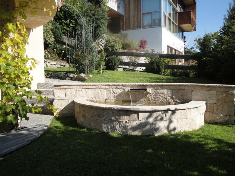 Brunnen aus Travertin Mauersteinen im Garten