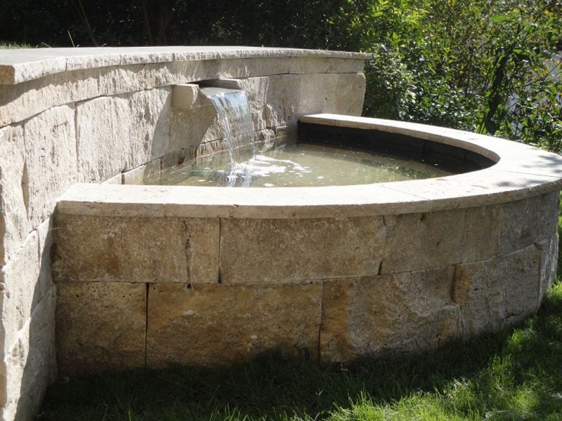 halbrunder Brunnen mit Mauer aus Naturstein