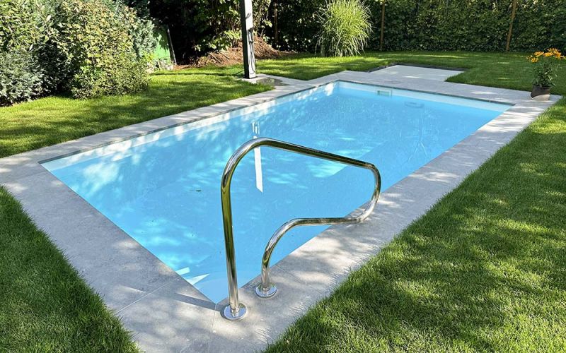 Pool mit hellgrauem, maßgefertigtem Kalkstein Beckenrand in schönem Garten
