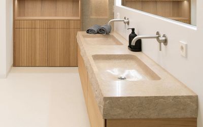 modernes Massiv-Doppelwaschbecken mit bossierter Kante aus Kalksteinblock in hellbeige